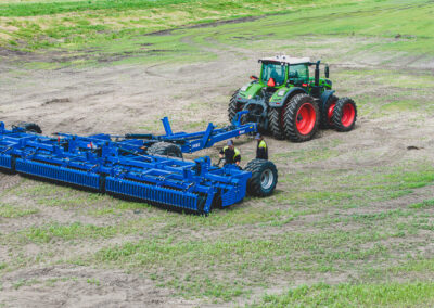 green tractor and blue equipment on farmland, redefining what a dealer can do